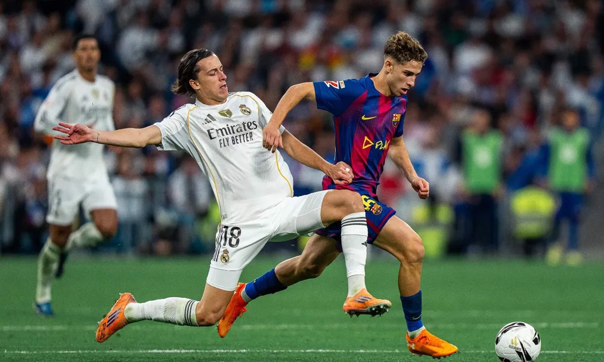 Álvaro Carreras disputando un balón con Fermín López en el Real Madrid - Barcelona.