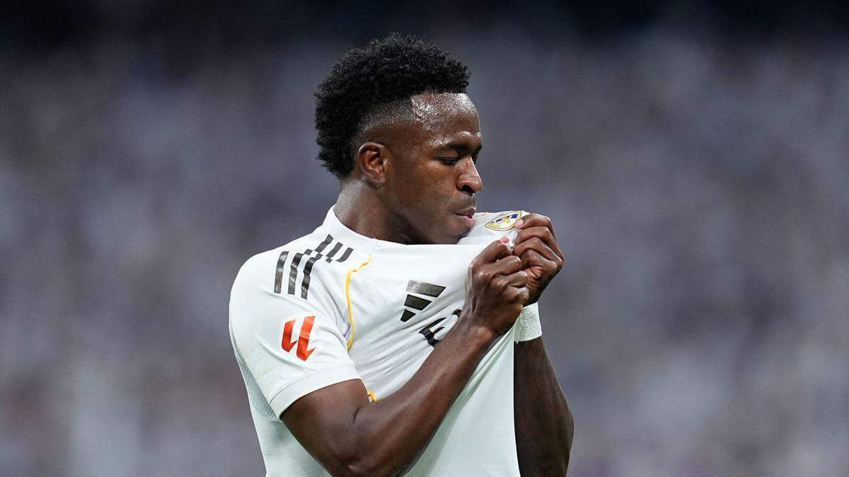 Vinícius Júnior besando el escudo del Real Madrid. 